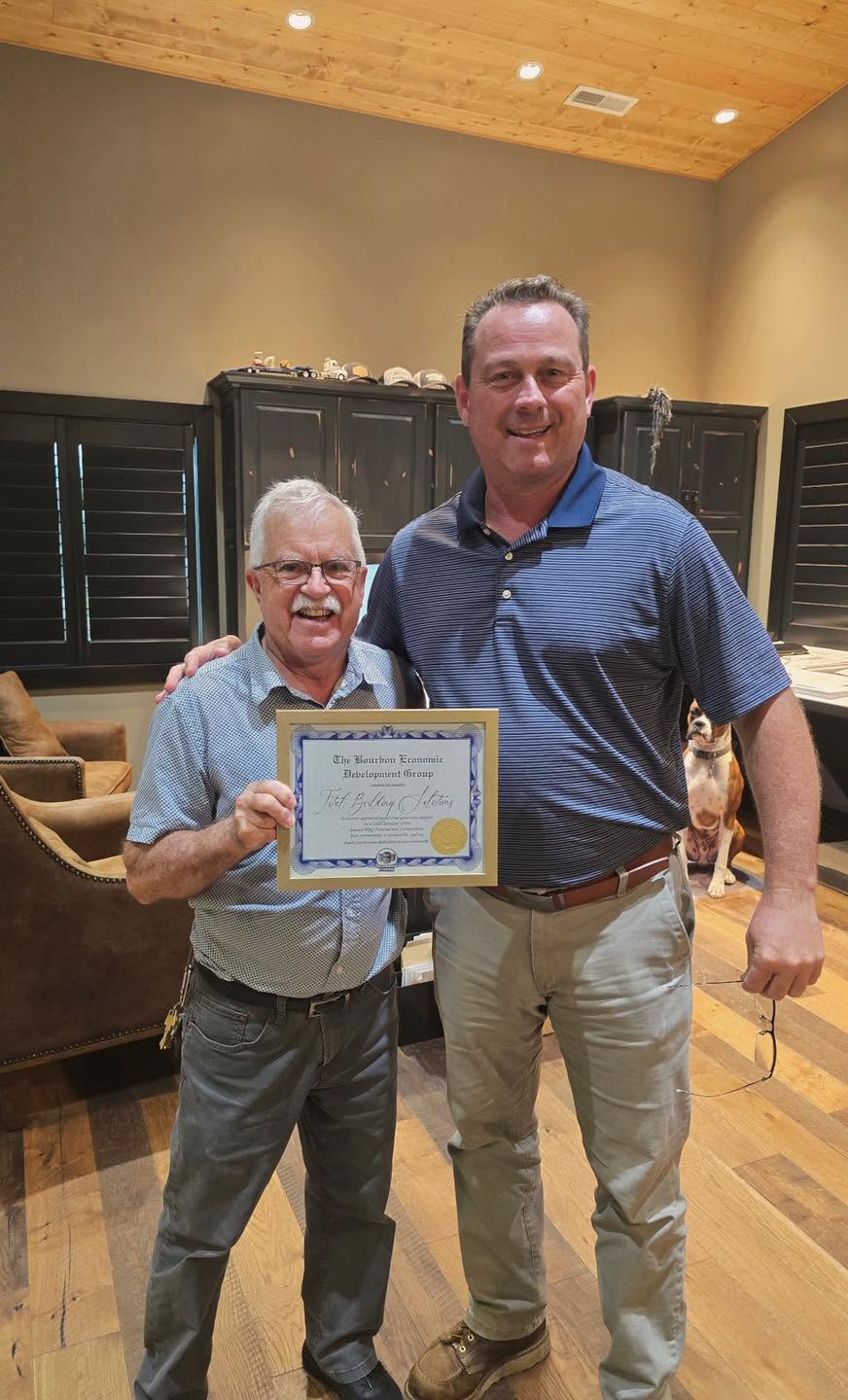 Total Building Solutions receiving a framed certificate of appreciation from the Bourbon Economic Development Group